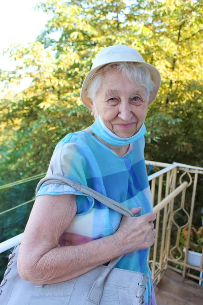 Covid Quot 安全和大流行病 Quot 戴着保护性医疗面具的老年孤独妇女站在家里的阳台上 以防止感染病毒 — 图库照片