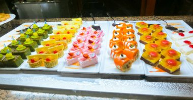 Açık büfedeki raflarda bulunan yiyecekler, Türkiye 'de soyut otel veya Kemer' deki tatil beldesindeki her şeyi kapsıyor. Tatlı kekler ve tatlı