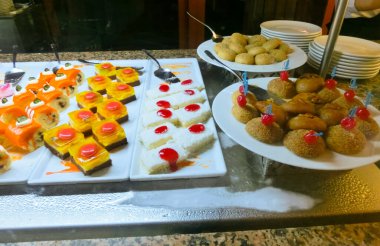 Açık büfedeki raflarda bulunan yiyecekler, Türkiye 'de soyut otel veya Kemer' deki tatil beldesindeki her şeyi kapsıyor. Tatlı kekler ve tatlı