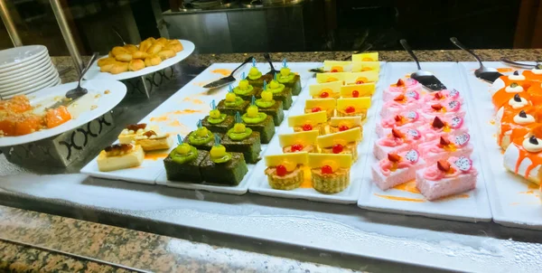 Açık büfedeki raflarda bulunan yiyecekler, Türkiye 'de soyut otel veya Kemer' deki tatil beldesindeki her şeyi kapsıyor. Tatlı kekler ve tatlı