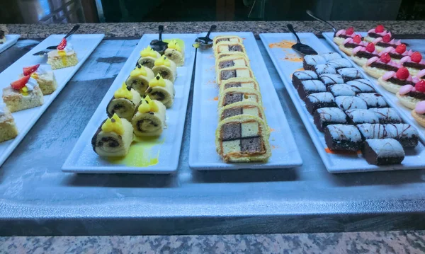 Açık büfedeki raflarda bulunan yiyecekler, Türkiye 'de soyut otel veya Kemer' deki tatil beldesindeki her şeyi kapsıyor. Tatlı kekler ve tatlı