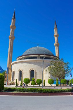 Antalya 'nın Kemer kentindeki cami, dağların arka planında ve mavi gökyüzünde