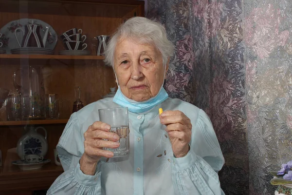 Mulher Cabelos Grisalhos Sênior Tomando Pílulas Segurando Copo Água Sentado — Fotografia de Stock
