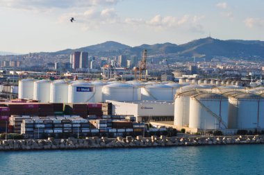 Barcelona, Spain - September 26, 2025: Meroil and Tradebe oil tanks terminal in port under sundown light at Barcelona, Spain on September 26, 2025