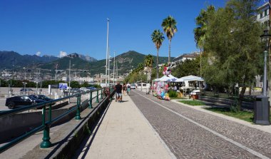 İtalya 'daki Salerno' da Santa Teresa plajında yürüyen ve bisikletle gezen insanların olduğu gezinti alanı..