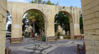 Valletta, Malta - 24 Eylül 2025: kemerler ve tarihi plaklar sizi toplara kadar uzanan manzaralı duvarlara götürüyor. Yukarı Barrakka Bahçeleri Valletta, Malta 'da halka açık bir bahçe..