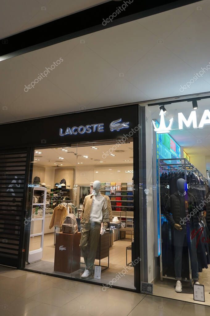 Barcelona, Spain - September 26, 2025: the exterior of a Lacoste store features a large sale sign. The glass facade displays a stylish design with merchandise visible inside the shop.