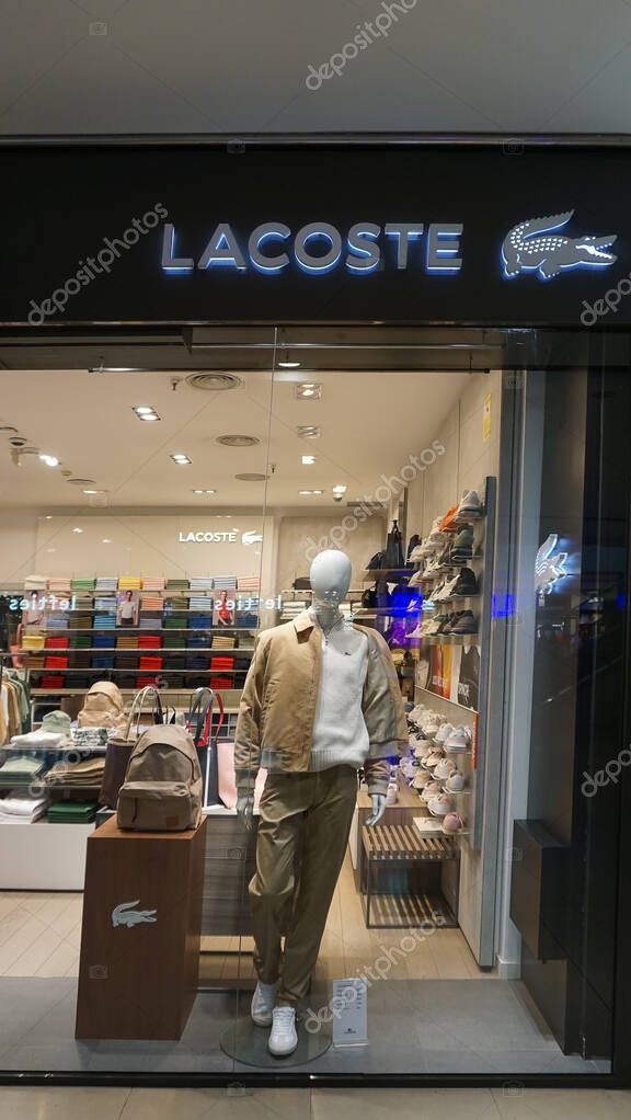 Barcelona, Spain - September 26, 2025: the exterior of a Lacoste store features a large sale sign. The glass facade displays a stylish design with merchandise visible inside the shop.
