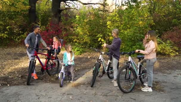 Счастливая семья показывает пальцы вверх после велопрогулки в парке — стоковое видео