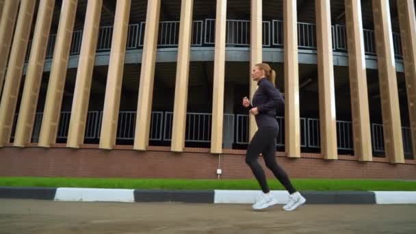 Вмістити жінку бігати навколо будівництва в місті — стокове відео