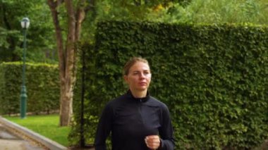 Sabah parkta koşan bir kadın.