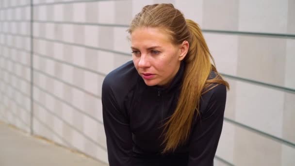 Corredor femenino respirando duro después de entrenar en la ciudad — Vídeo de stock