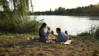 Nehir kenarında piknik yapan mutlu bir aile.