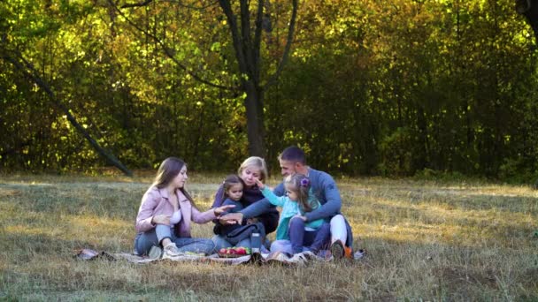 Padres e hijos se unen a las manos en el picnic — Vídeos de Stock