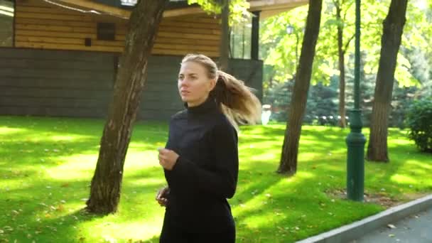 Atletisk kvinna som springer i parken på solig dag — Stockvideo