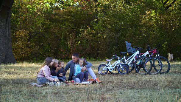 Familie ontspannen bij de picknick na het fietsen — Stockvideo