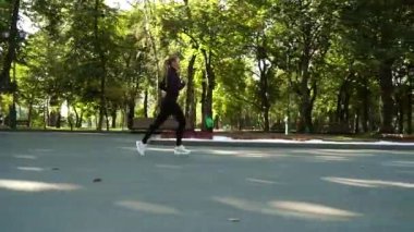 Sabah parkta koşan bir kadın.