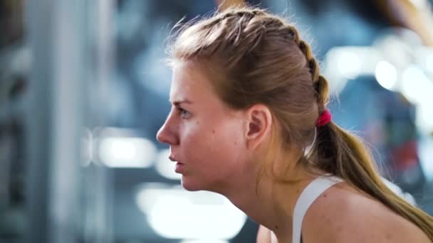 Сильна жінка піднімає гантелі в спортзалі — стокове відео