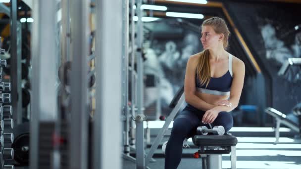 Kvinna avkopplande efter träning med hantlar i gym — Stockvideo
