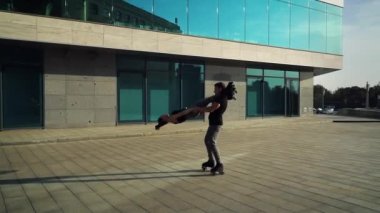 Paten kayan akrobatlar modern binanın yakınlarında sıra dışı numaralar yapıyorlar.