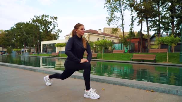 Fit Frau streckt Beine vor Ausdauertraining in Wassernähe — Stockvideo