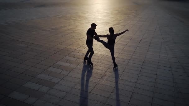 Silhouettes de patineurs à roulettes effectuant des tours extrêmes au coucher du soleil — Video