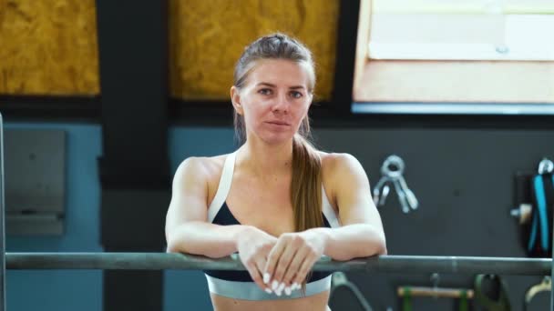 Młoda kobieta w odzieży sportowej pozuje na siłowni — Wideo stockowe