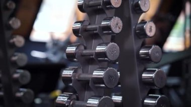 Kadın elleri spor salonundan dambılları alıyor.