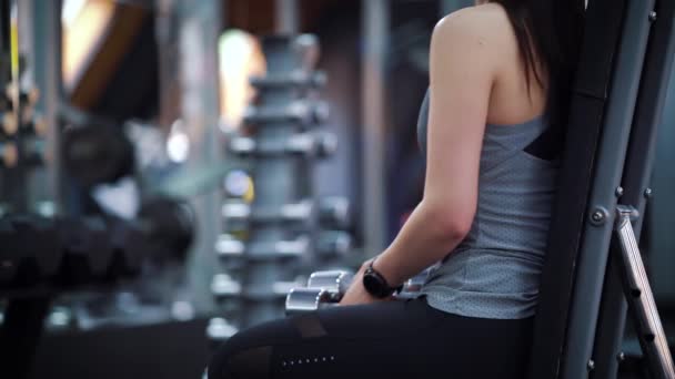Jeune femme levant haltères dans la salle de gym — Video