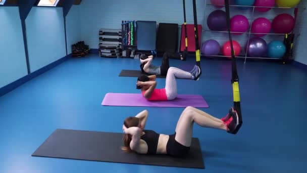 Grupo de mujeres multiétnicas entrenando con correas TRX en el gimnasio — Vídeo de stock