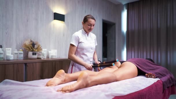 Therapeut macht Massage mit Bambusstäben für Wellness-Spa-Kunden — Stockvideo