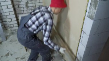 İnşaat alanında alçıyla çalışan bir inşaat işçisi.