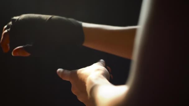 Female boxer wrapping hand with bandage before fight — Stock Video