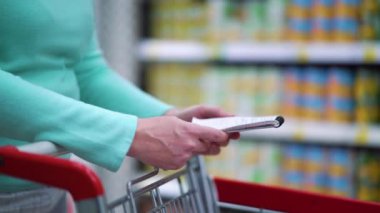 Süpermarkette kadın eller alışveriş listesini tutuyor