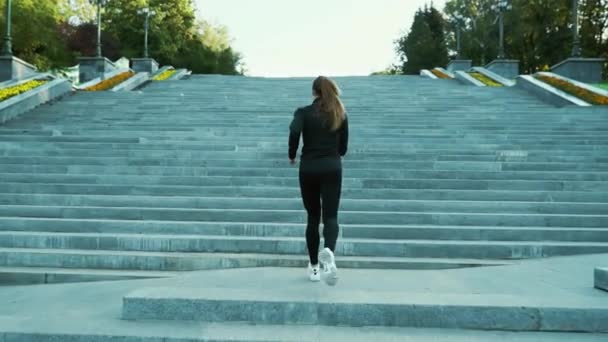 街の長い階段を駆け上がるフィット女性 — ストック動画