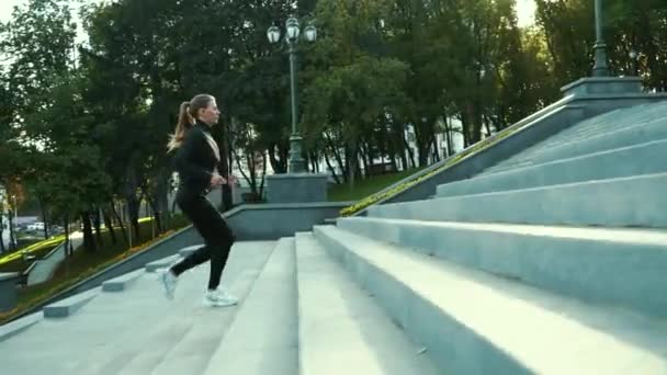 Fit kvinde jogging ovenpå i byens park – Stock-video