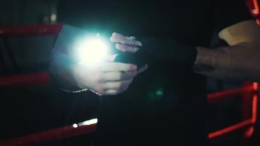 Boksör boks ringinde elleri bandajlıyor.