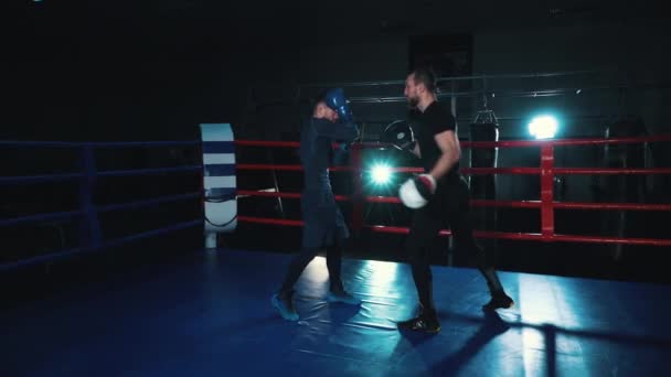 Bokser ćwiczy z trenerem na ringu bokserskim — Wideo stockowe