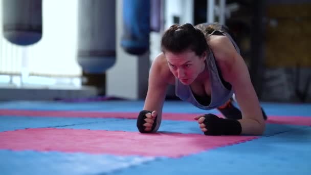 Boxer féminin faisant planches trempettes de hanche dans la salle de gym — Video