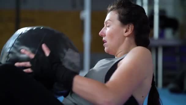 Fit kobieta oddycha ciężko podczas wykonywania chrupania z ciężką piłką — Wideo stockowe