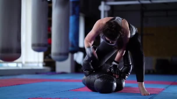 Женщина ММА практикует со спортивным манекеном в спортзале — стоковое видео