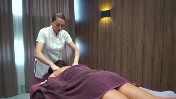 Terapista massaggiando parte superiore della schiena del cliente del salone di benessere — Video Stock