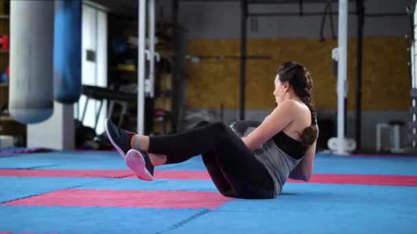 Mulher fazendo crunches com bola pesada no ginásio — Vídeo de Stock