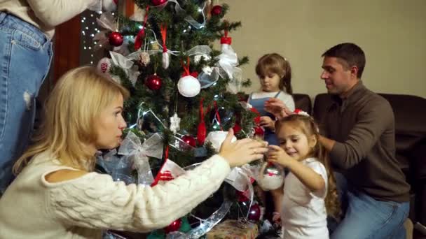 Gran familia decorando el árbol de Navidad con adornos — Vídeo de stock