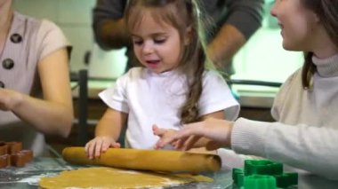 Aile mutfakta birlikte ev yapımı kurabiye yapıyor.