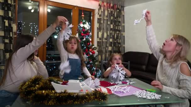 Mère et les enfants jouent avec des flocons de papier contre l'arbre de Noël — Video