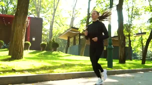 フィット女性ジョギングで公園でスローモーション — ストック動画