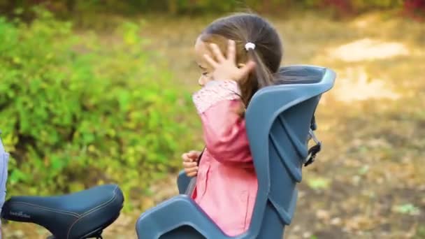 Klein meisje in kinderzitje op fietstocht met vader — Stockvideo