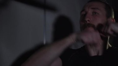 Boksör spor salonunda yumruk topuyla çalışıyor.