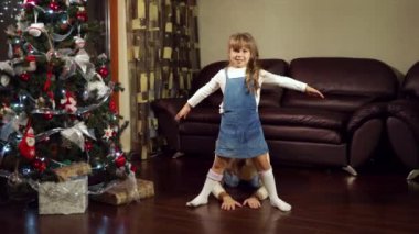 Anne ve kızı Noel ağacının yanında eğleniyor.